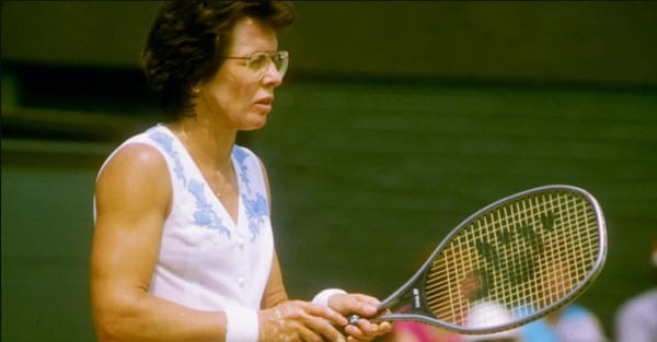 Billie Jean King holding a tennis racket. 